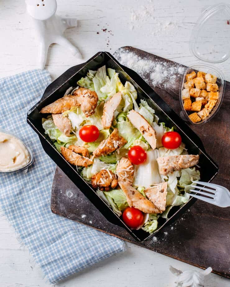 A Caesar salad with grilled chicken, croutons, parmesan cheese, and creamy Caesar dressing