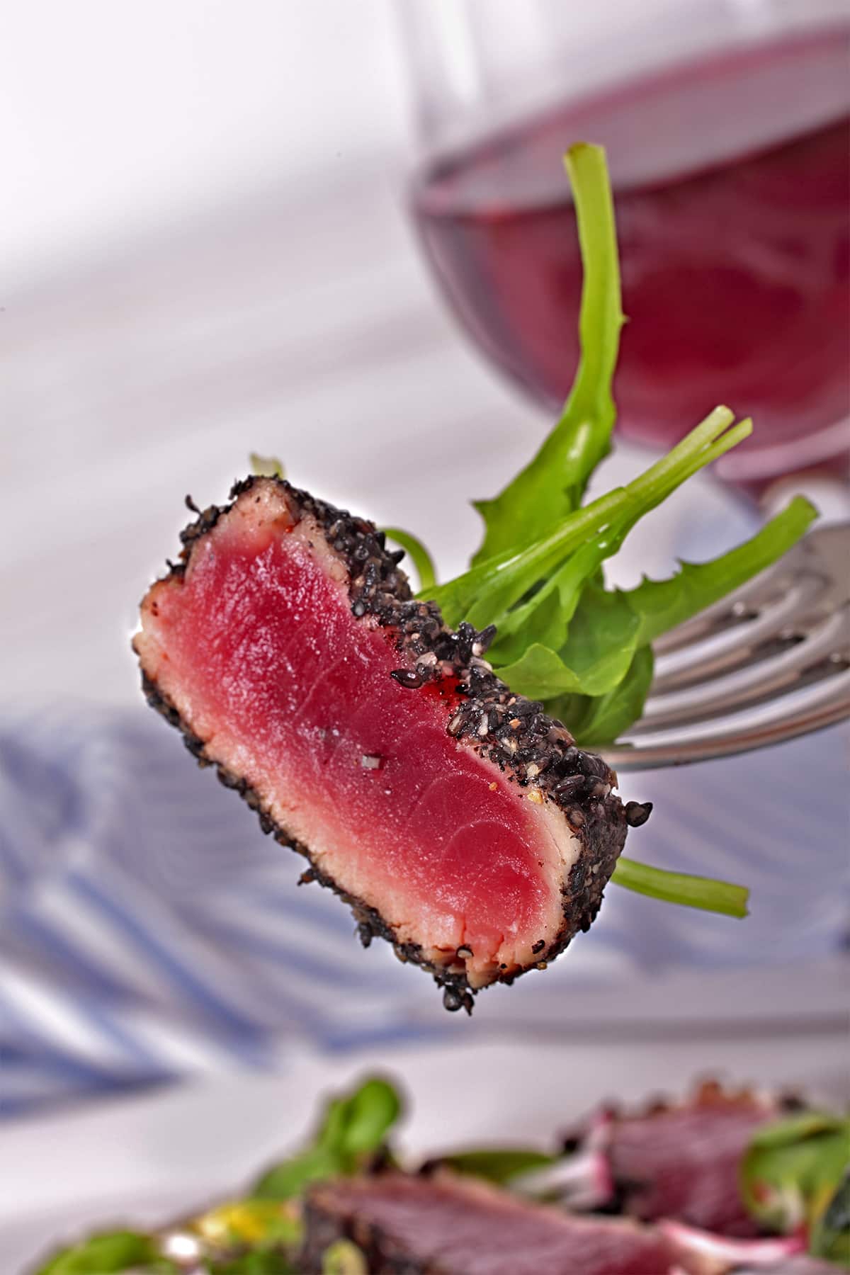 Close-up of seared sesame-crusted tuna with fresh greens, satisfying a craving for tuna.