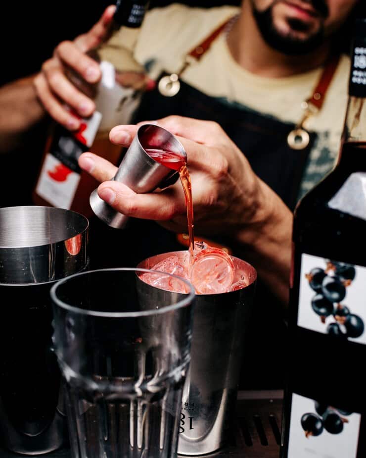 A bartender mixing Crown Royal whiskey and Watermelon Pucker Schnapps for a Strfkr Shot