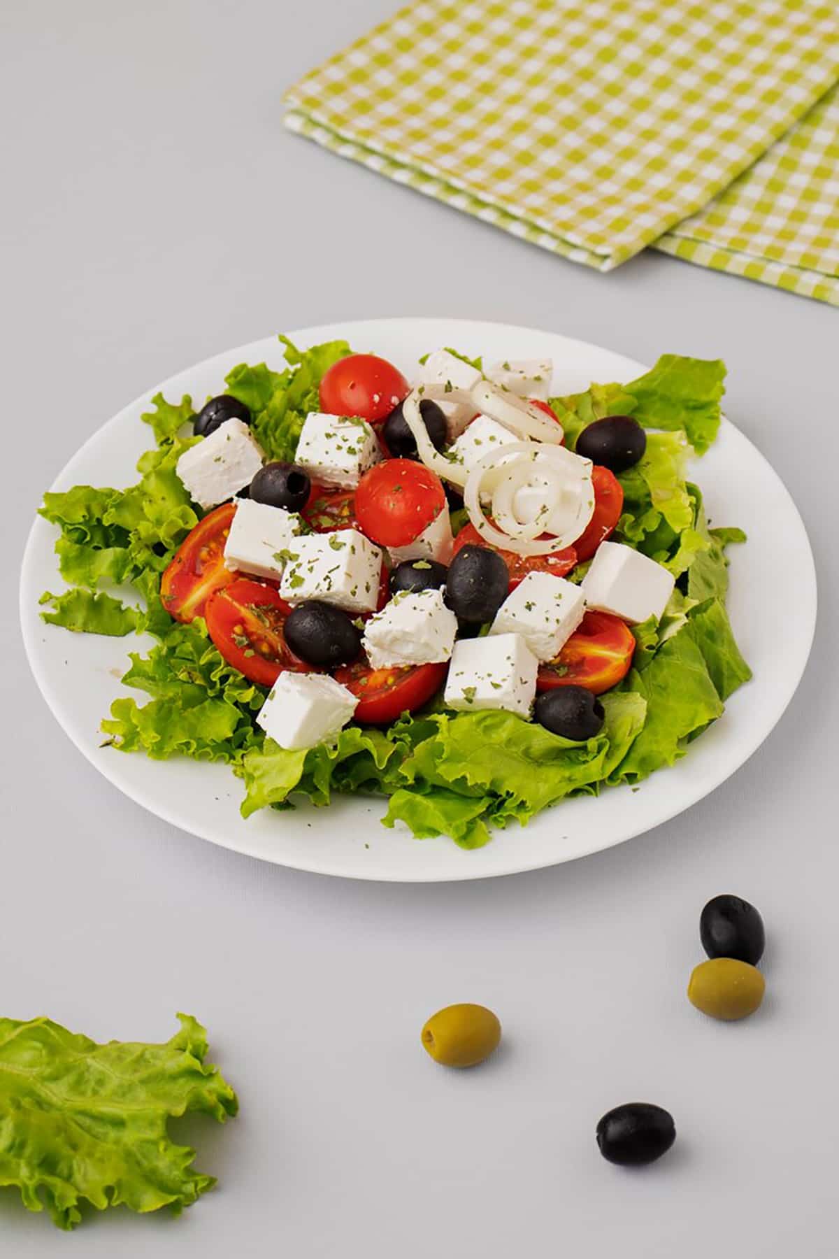 Greek salad topped with crumbled white feta cheese and fresh vegetables